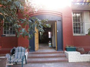 looking into our home  from the street .The wooden door invites us in ,and the long corridor leads throughout the once dark entrance to another space ,more windows .Looking in ,looking through and looking out